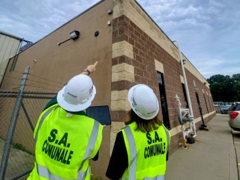 Two S.A. Comunale technicians inspect a commercial security system 